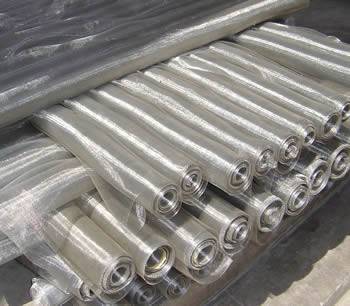 Several rolls of stainless steel insect screen are on the ground.