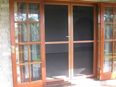 Two stainless steel insect screen doors are closed and two glass doors are open.